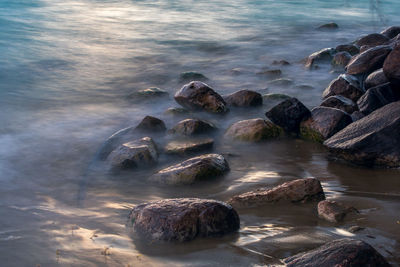 Rocks on sea shore against sky