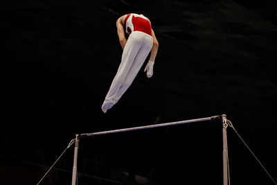 Low angle view of athlete performing acrobatics in gym