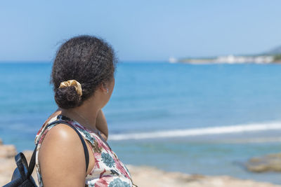 Woman of moroccan origin looking at an out of focus sea. new generation concept