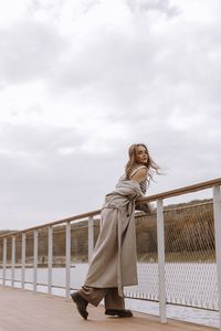 Side view of woman standing against sky