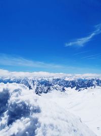 Scenic view of snowcapped mountains against blue sky