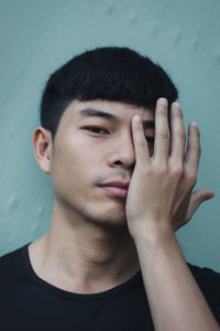 Close-up portrait of young man against wall