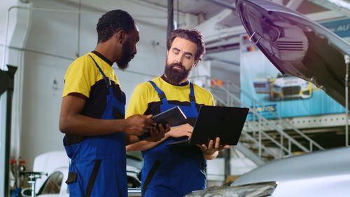 Side view of man using digital tablet while standing at airport