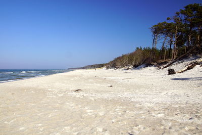 Scenic view of beach against clear blue sky