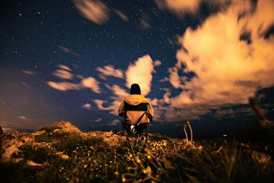 Man on landscape against sky at night