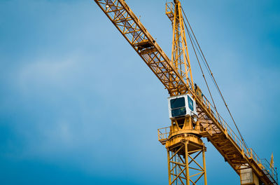 Low angle view of crane against sky