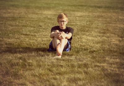 Portrait of happy girl sitting on field