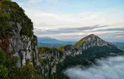 Scenic view of mountain by sea against sky