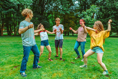 Rear view of friends running on field