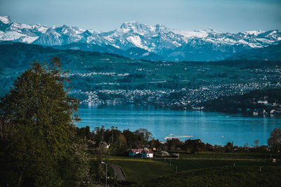 Scenic view of lake by mountains against sky