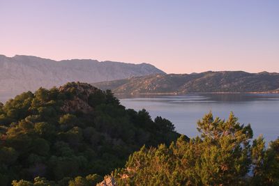 Scenic view of lake and mountains against clear sky