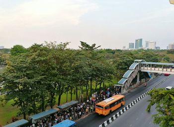 Road amidst trees against sky in city