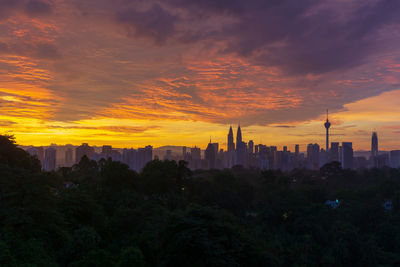 Buildings in city against sky during sunset