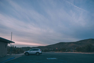 Cars on road against sky during sunset