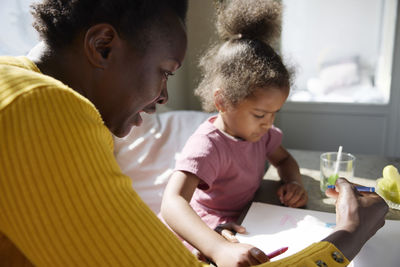 Mother and daughter drawing together