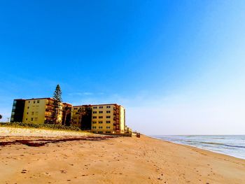 Scenic view of beach against clear blue sky