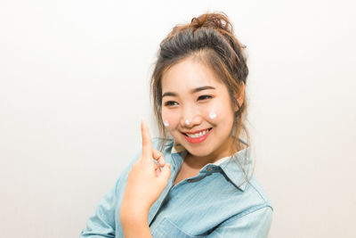 Portrait of young woman against white background