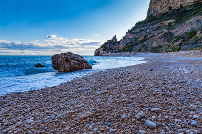 Rocks on beach against sky