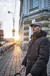 Side view of man looking at city street