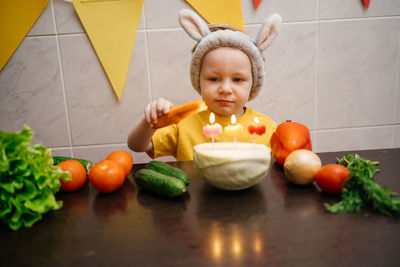 Vegetarian cake with candles birthday vegetables baby in rabbit ears copy space. high quality photo