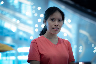 Portrait of woman standing against illuminated lights