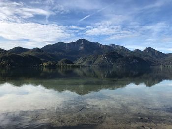 Scenic view of lake by mountains against sky