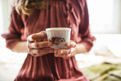 Midsection of woman drinking coffee in cup