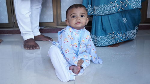 Portrait of cute boy sitting on floor