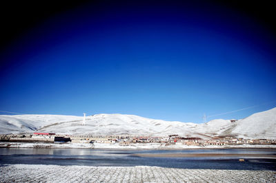 Scenic view of snowcapped mountains against clear blue sky