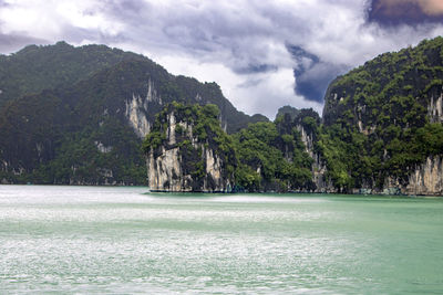 Scenic view of sea and mountains against sky