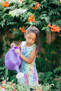 Portrait of smiling young woman standing by plants