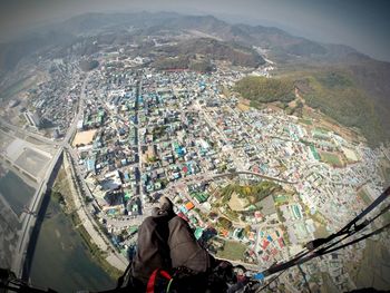 Low section of man paragliding over cityscape