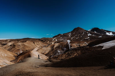 Scenic view of snowcapped mountains against clear blue sky