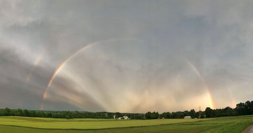 Scenic view of rainbow over landscape against sky