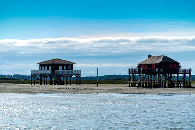 Built structure on beach by building against sky