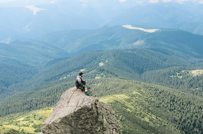 High angle view of man sitting on cliff