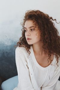 Young woman looking away against clear sky