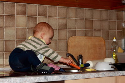 Rear view of boy sitting at home