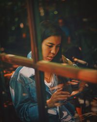 Woman using mobile phone in cafe