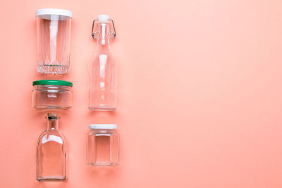 Close-up of various glass bottles against peach background