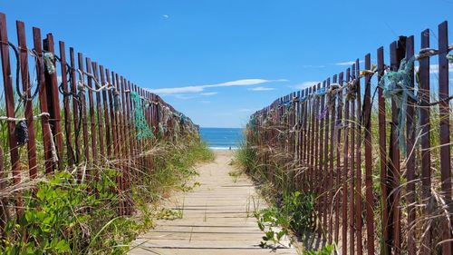 Panoramic view of wooden posts amidst sea against sky