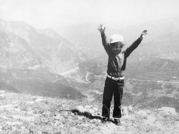 Full length of woman standing on cliff