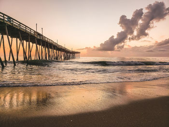 Pier over sea against sky during sunset