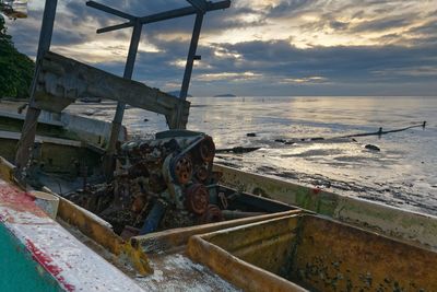 Abandoned ship at sea shore against sky