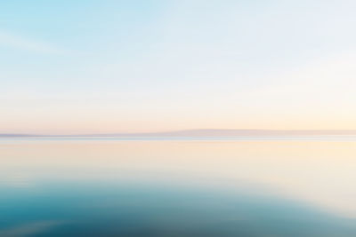 Scenic view of sea against clear sky at sunset