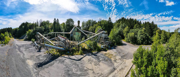 Panoramic view of road amidst trees against sky