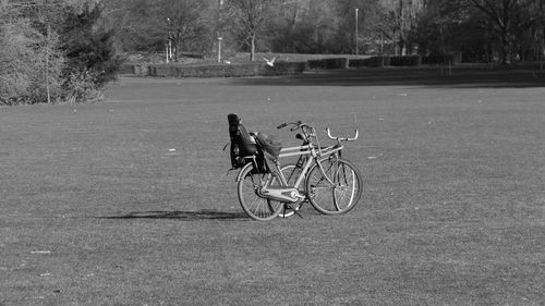 Man riding bicycle on field in city