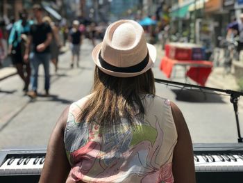 Rear view of woman performing on street in city