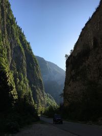 Cars on mountain road against clear sky