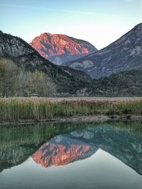 Scenic view of lake by mountains against clear sky